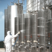 un operaio si dedica all'isolamento termico di serbatoi per olio spruzzando il rivestimento termico Savenergy.it