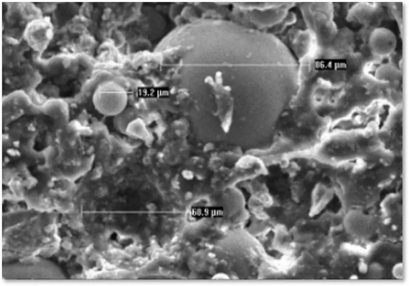 Micrografia SEM reale di Manti Ceramic con microsfere di diverse dimensioni distribuite nella matrice del materiale.